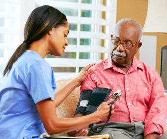 female caregiver checking on senior man